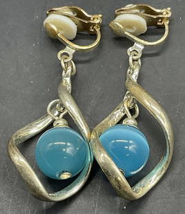 Vtg Blue Bead Drop Twist Dangle Clip On Earrings: Vintage stylized twisted teardrop / abstract geometric shaped clip on earrings crafted from metal. Suspended within the lower curve of this metal frame is a smooth, round, turquoise blue colored bead.