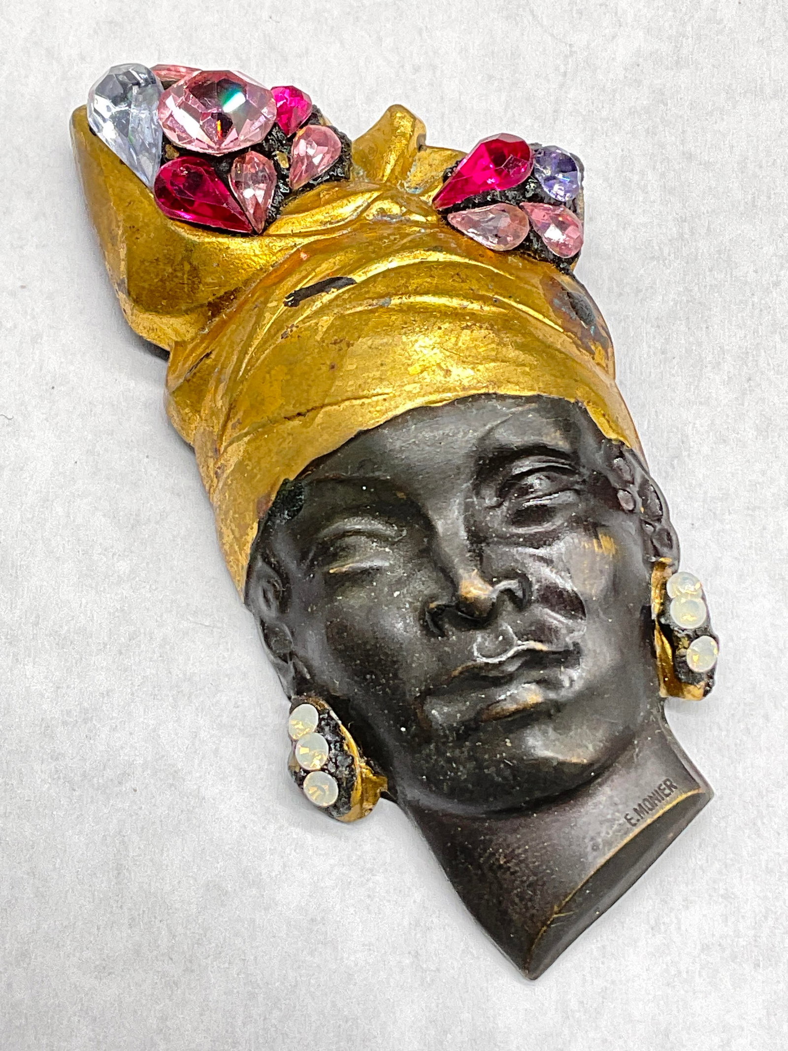 E. MONIER Vtg Bejeweled Metal Female Bust Brooch: E. MONIER Vintage Bejeweled Metal Female Bust Brooch. Metal pin closure to reverse. Signed E. MONIER to obverse. Measures approx. 2.5L x 1.25W in. Discoloration, chipping, and surface wear present. Vi