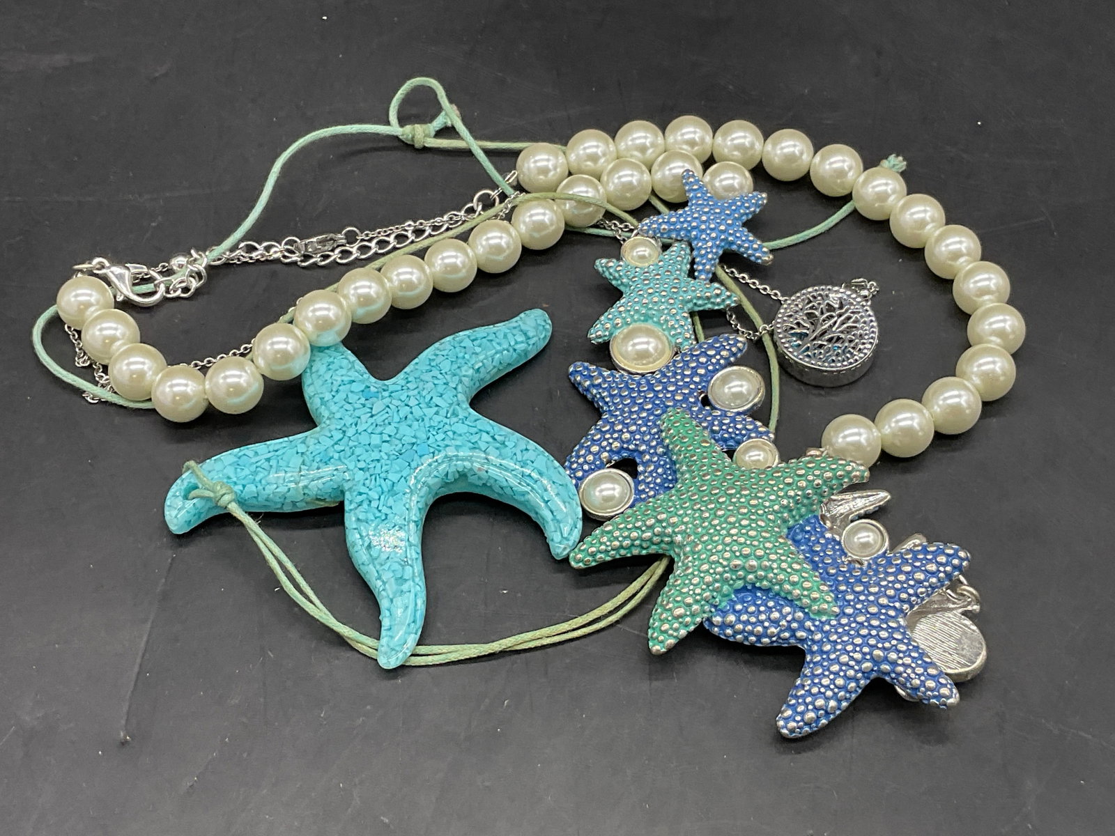 3 Nautical Beachcomber & Nature Motif Necklaces: Lot of 3 Nautical Beachcomber & Nature Motif Necklaces. Pieces are crafted from metal, composite, or pearlescent beads. Starfish motifs to the nautical beachcomber necklaces and a pierced metal tree p
