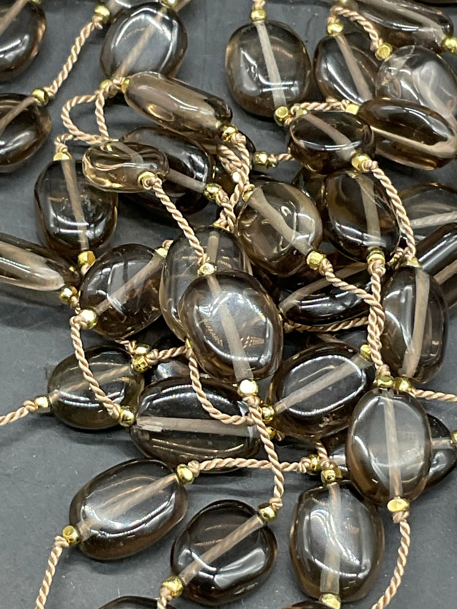 Vintage Beaded Lariat Necklace: Gold tone metal and smokey black-gray beaded cord lariat necklace. Necklace measured end to end approx. 59 inches in length. Surface wear consistent with age, use, and exposure. Vintage jewelry, Vinta