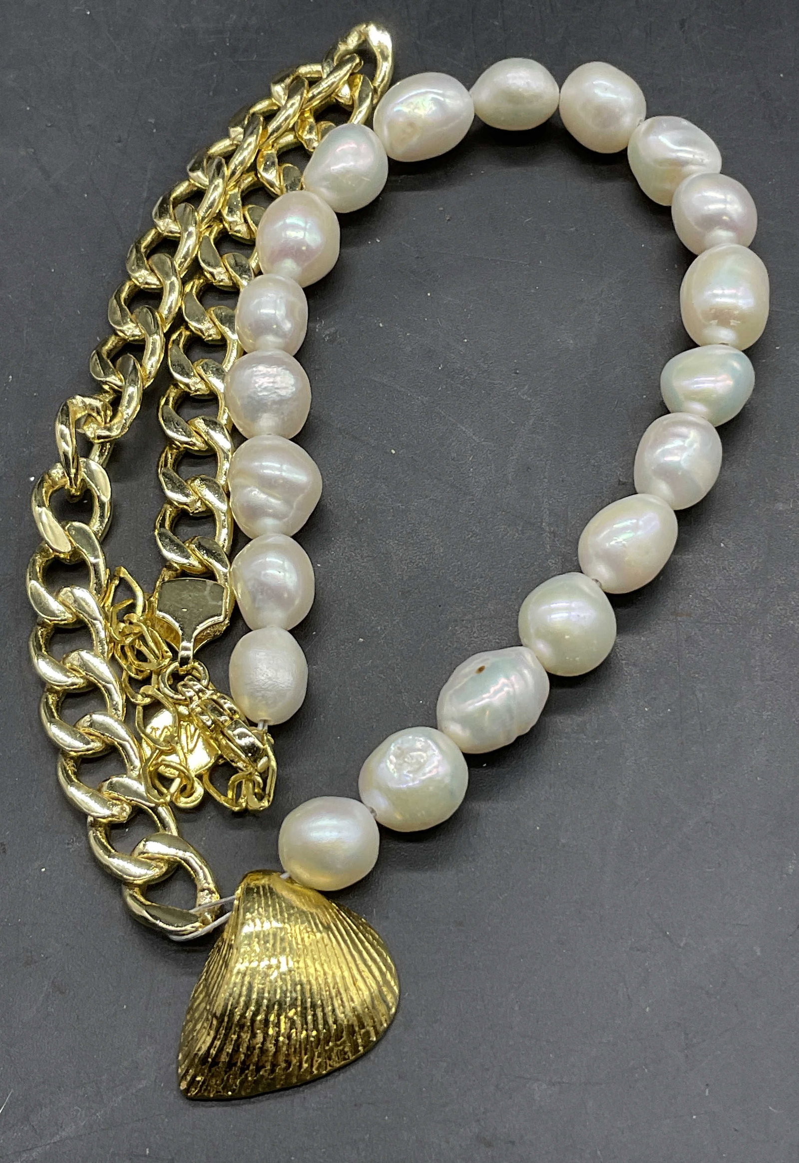 MM Trademarked Freshwater Pearl Necklace: MM Trademarked Freshwater Pearl Necklace. Gold tone metal chain necklace featuring freshwater pearls and a gold tone metal clamshell pendant. Clasp marked MM. Length measured end to end approx. 18.25 