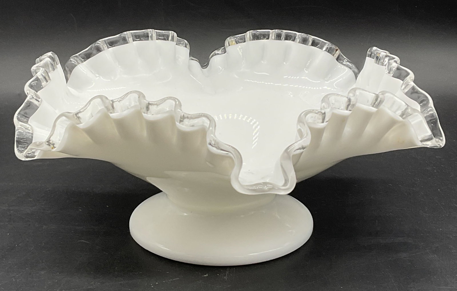 Vintage Ruffled Rim Milk Glass Pedestal Bowl: Vintage Ruffled Rim Milk Glass & Clear Glass Pedestal Bowl. Measure approx. 3.75H x 7W in. Surface wear consistent with age, use, and exposure. Seam present. Imperfections to glass. home decor, home a
