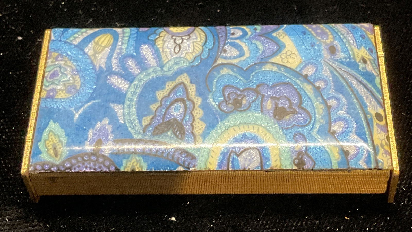 Vtg Gold Tn Blue Enamel Paisley Trinket Box: Vintage gold tone trinket pill box with blue paisley pattern enamel. Measures approx 2 x 1 x .25 inches. Some wear consistent with exposure. Inventory from Manhattan Jewelry store circa 1950s-1960s. T