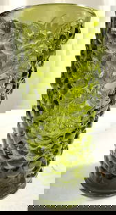 MCM Avocado Green Glass Vase W Grape Pattern: Vase is mid century modern. Piece is avocado green toned with grape pattern detail to exterior. Vessel is glass. Piece measures approximately 7.5 inches tall 3.75 inches wide. Vase, avocado green vase