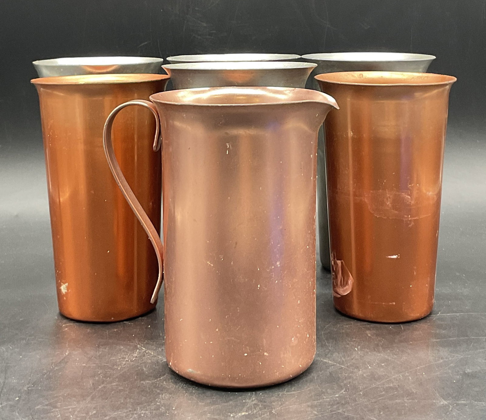Lot 7 COLOR CRAFT Vintage Metal Cups & More: Lot 7 COLOR CRAFT Vintage Metal Cups & Pitcher and Unsigned Vintage Metal Cups. Silver tone metal cups measure approx. 5.25H x 3W in. Some pieces are marked COLOR CRAFT on the underside. Surface wear 