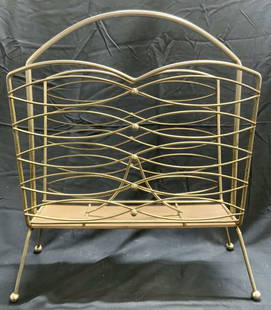 Vtg MCM Footed Metal Magazine Holder Magazine Rack: Magazine rack is metal, mcm, atomic style. Piece has 4 splayed legs and spherical form feet. Rack has arch form handle. Piece measures approximately 19.25 inches tall 16.25 inches wide 7 inches deep.