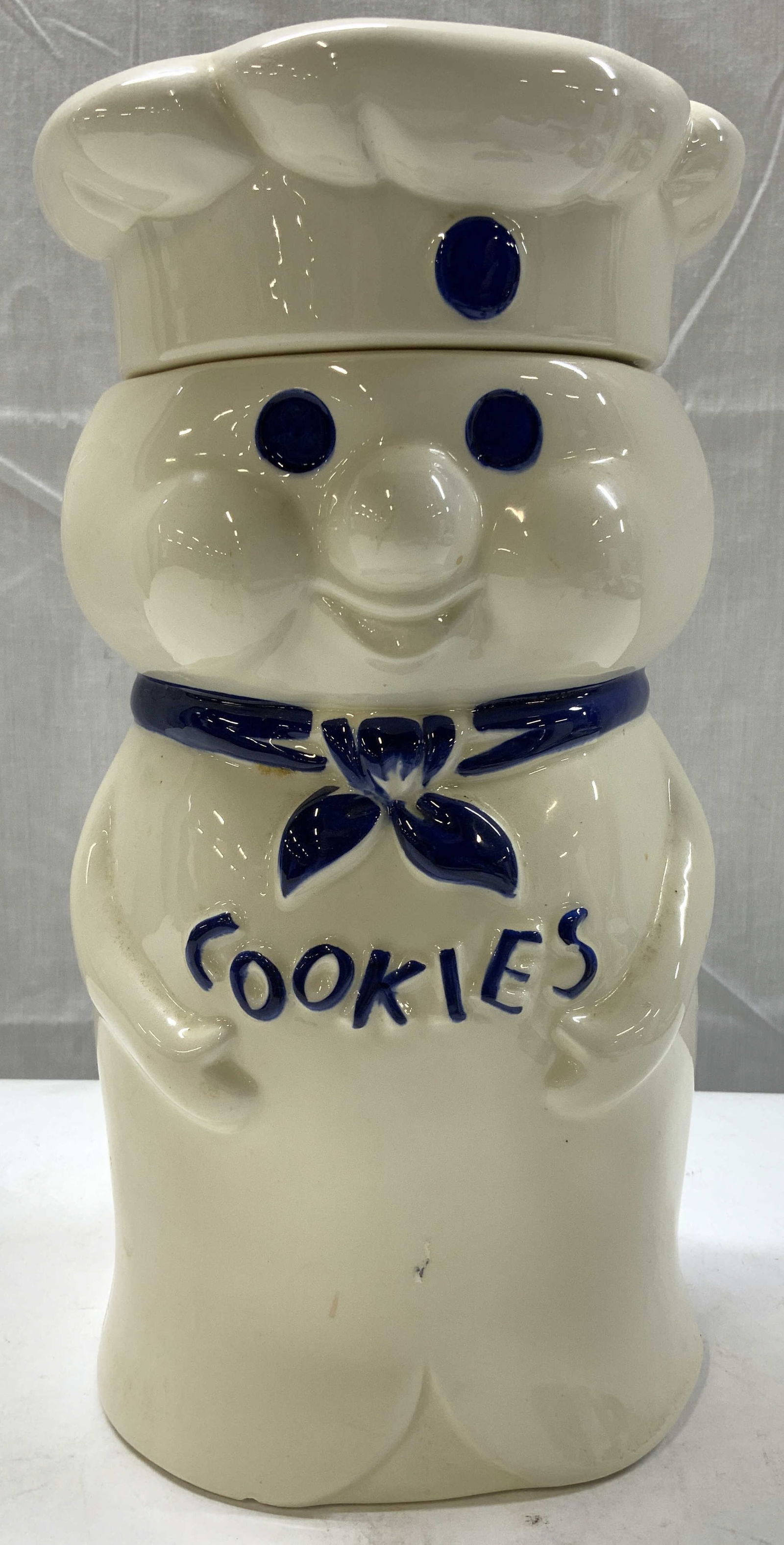 Vntg Pillsbury Doughboy Ceramic Cookie Jar: Vntg Pillsbury Doughboy Ceramic Cookie Jar Cookie jar depicting Pillsbury Doughboy character wearing a chefs hat & a blue neckerchief with COOKIES lettering. Surface wear consistent to age, use & expo
