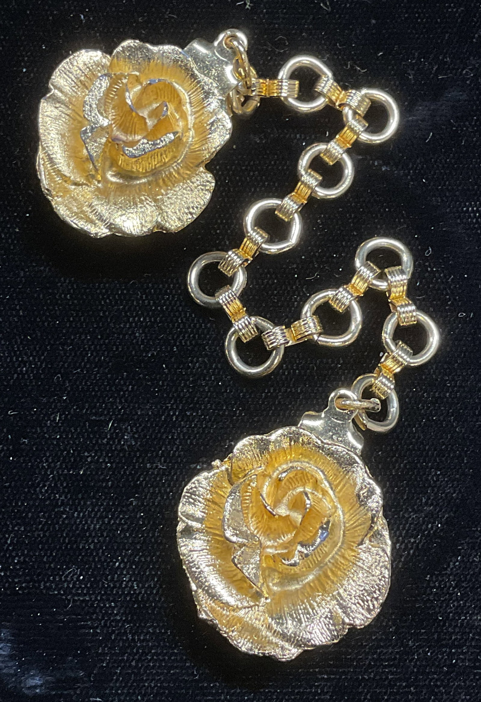 Vintage Gold Tone Flower Sweater Clips: Vintage gold tone flower motif sweater clips on chain. Clip measure approx 1 inch wide. Some wear including scratching observed. Inventory from Manhattan Jewelry store circa 1950s-1960s. Jewelry, esta