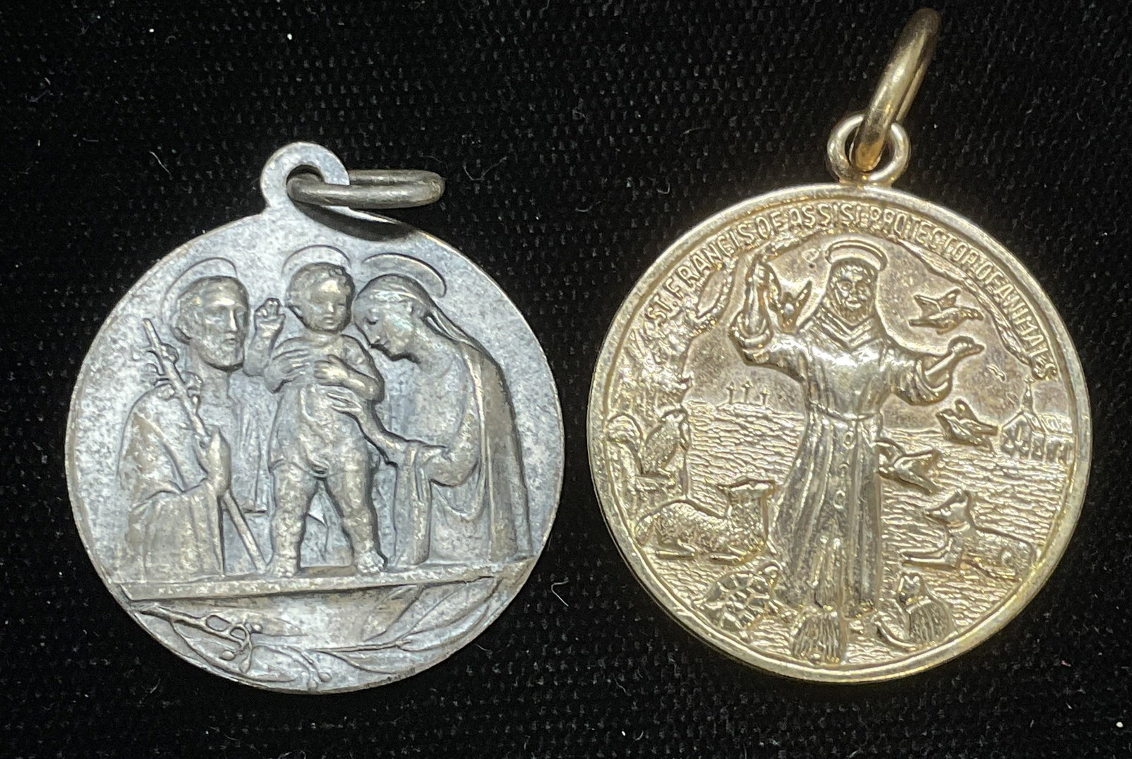 Lot 2 H Shelling St Francis Pendant +: Lot of 2 religious pendants. H Shelling st Francis pendant and silver tone pendant with image of Jesus, Mary, and Joseph. Measure approx 1 inch wide. Some wear including scratching observed. Jewelry, 