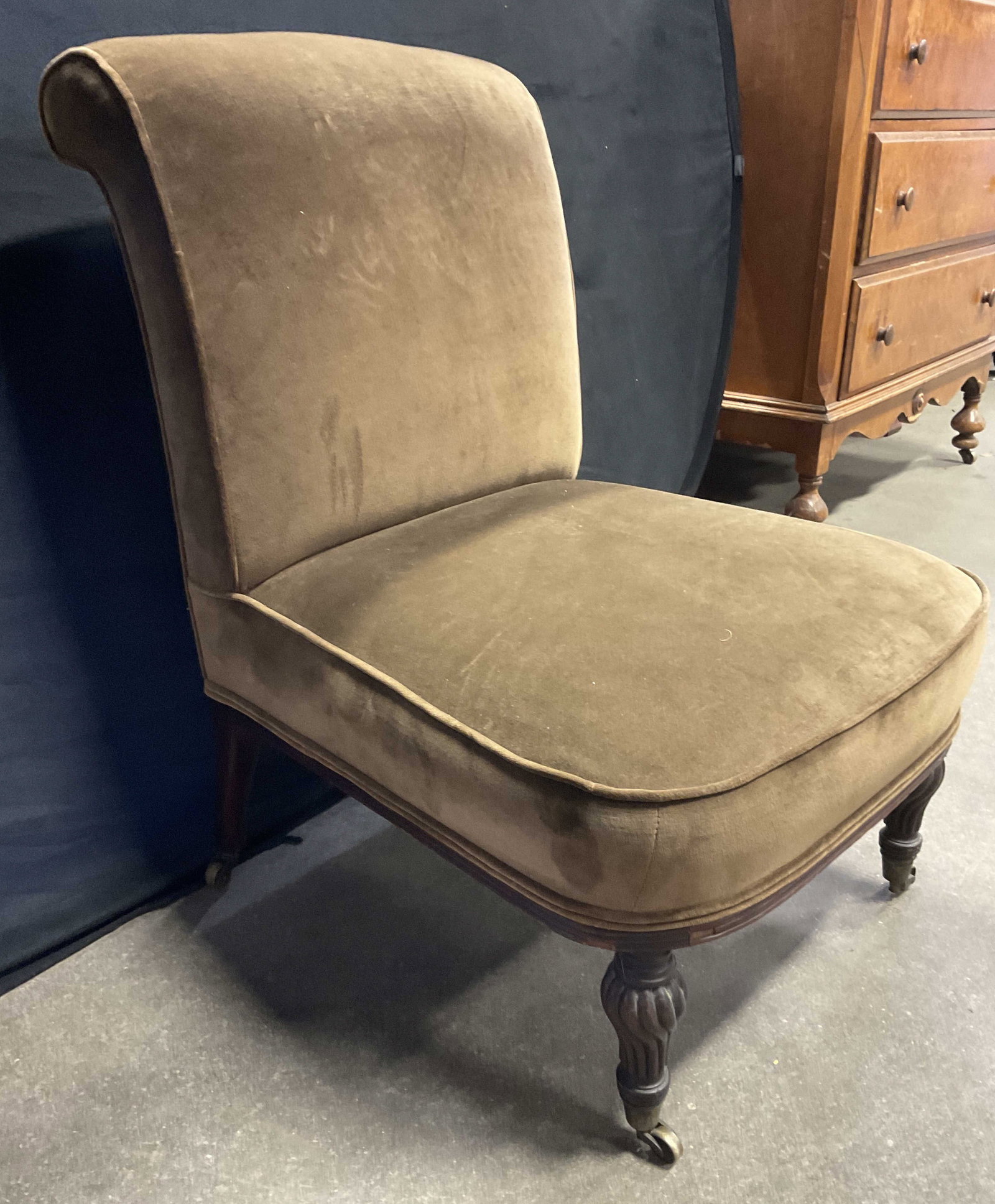Vintage Brown Velvet Upholstery Chair on Casters: Vintage Brown Velvet Upholstery Chair on Metal Casters. Scrolled back. Wooden legs to the piece. Measures approx. 31H x 22D x 22W in. Discoloration, chipping, surface wear, and losses to fabric. home 