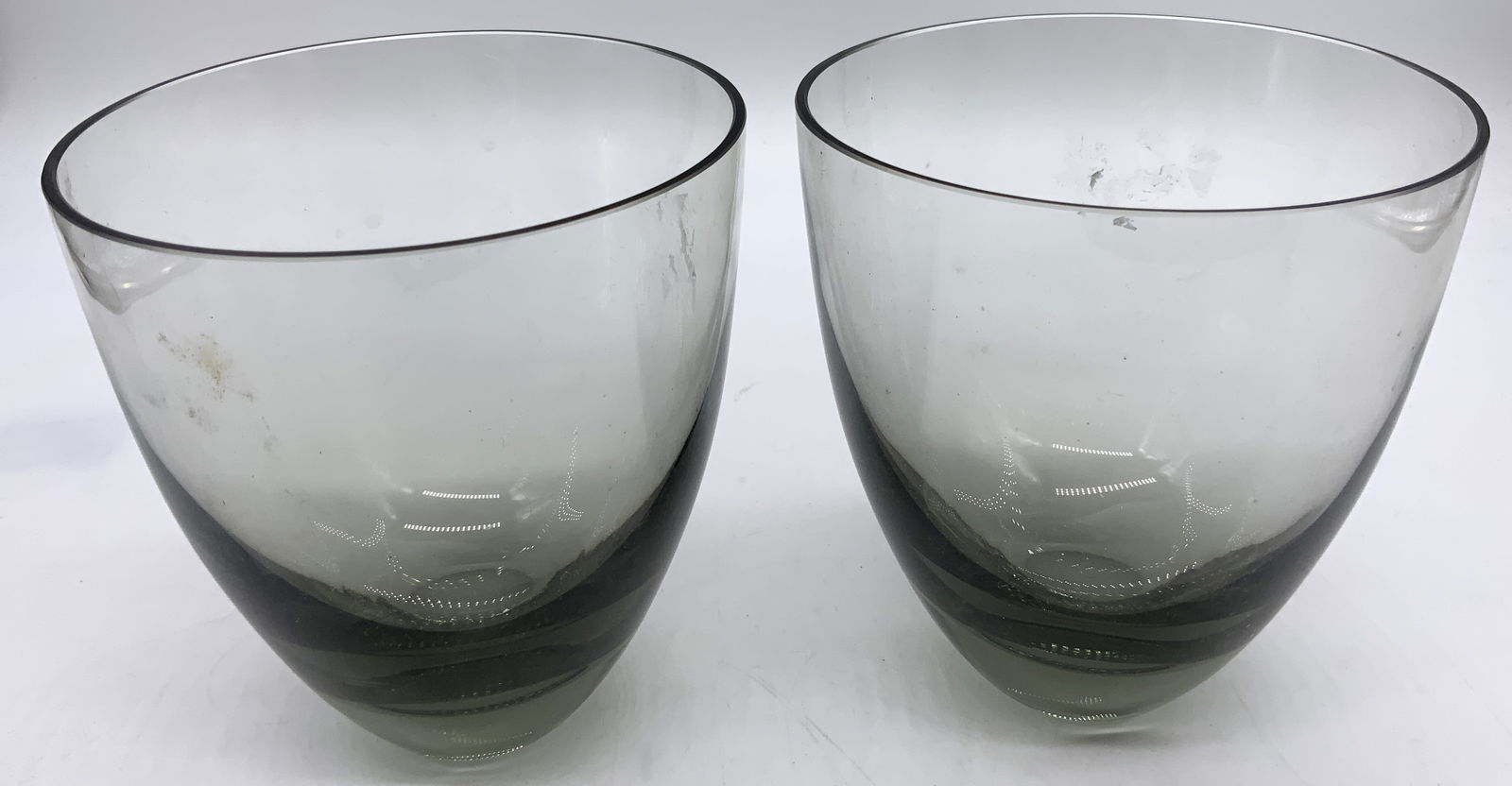 2 HOLMEGARRD Vintage Smokey Gray Glasses: 2 HOLMEGARRD Vintage Smokey Gray Glasses 2 tall round glasses with a smokey gray color. Possible Holmegaard. Surface wear consistent to age, use & exposure. Measurements: length 4.5in x width 4.5in x
