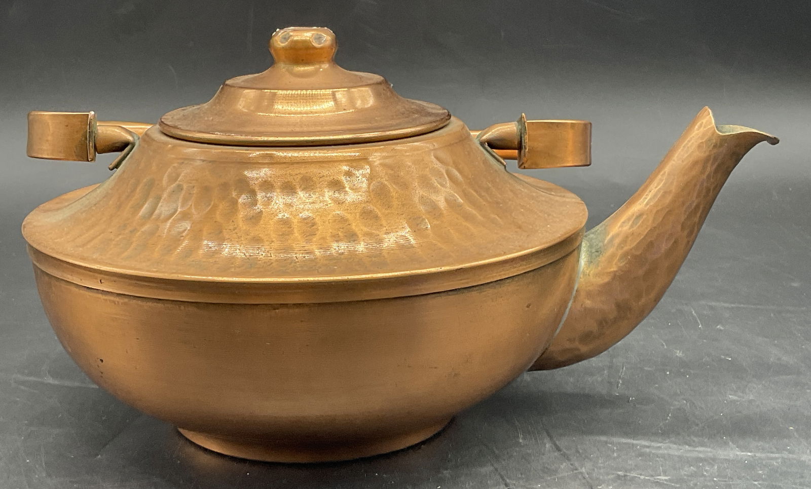 GREGORIAN COPPER Hammered Top Handle Kettle: GREGORIAN COPPER Hammered Top Handle Kettle. Measures approx. 4.75H x 8.5W in. Measured at widest point. Height includes lid. The top handle is adjustable. Underside reads GREGORIAN COPPER. Surface we