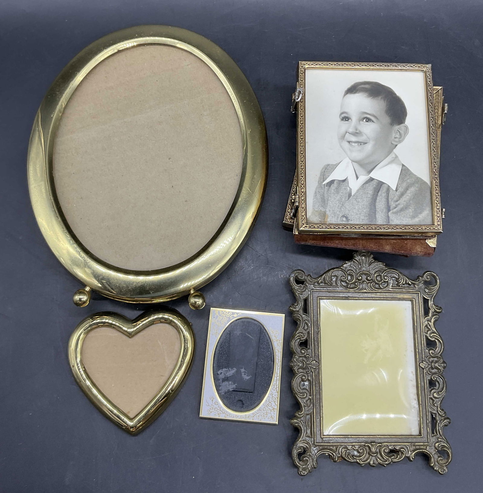 Lot 5 Vintage Brass Toned Metal Picture Frames: Lot of 5 Vintage Brass Toned Metal Picture Frames. Most pieces feature brass hues. Largest measures approx. 7.75L x 6.25W in. Some pieces need repair. Losses, separation, missing pieces, discoloration