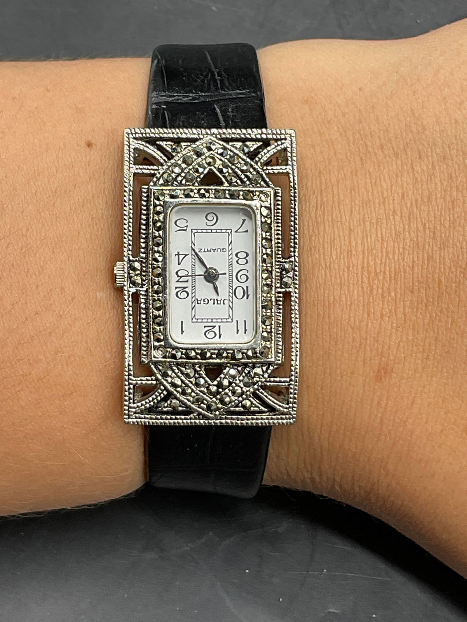 JAGLA QUARTZ Marcasite & Black Leather Watch: Vintage JAGLA QUARTZ Marcasite & Black Leather Watch. Rectangular watch face that reads JAGLA QUARTZ and is studded with marcasite. Black leather band to the piece. End to end measures approx. 8.5 inc