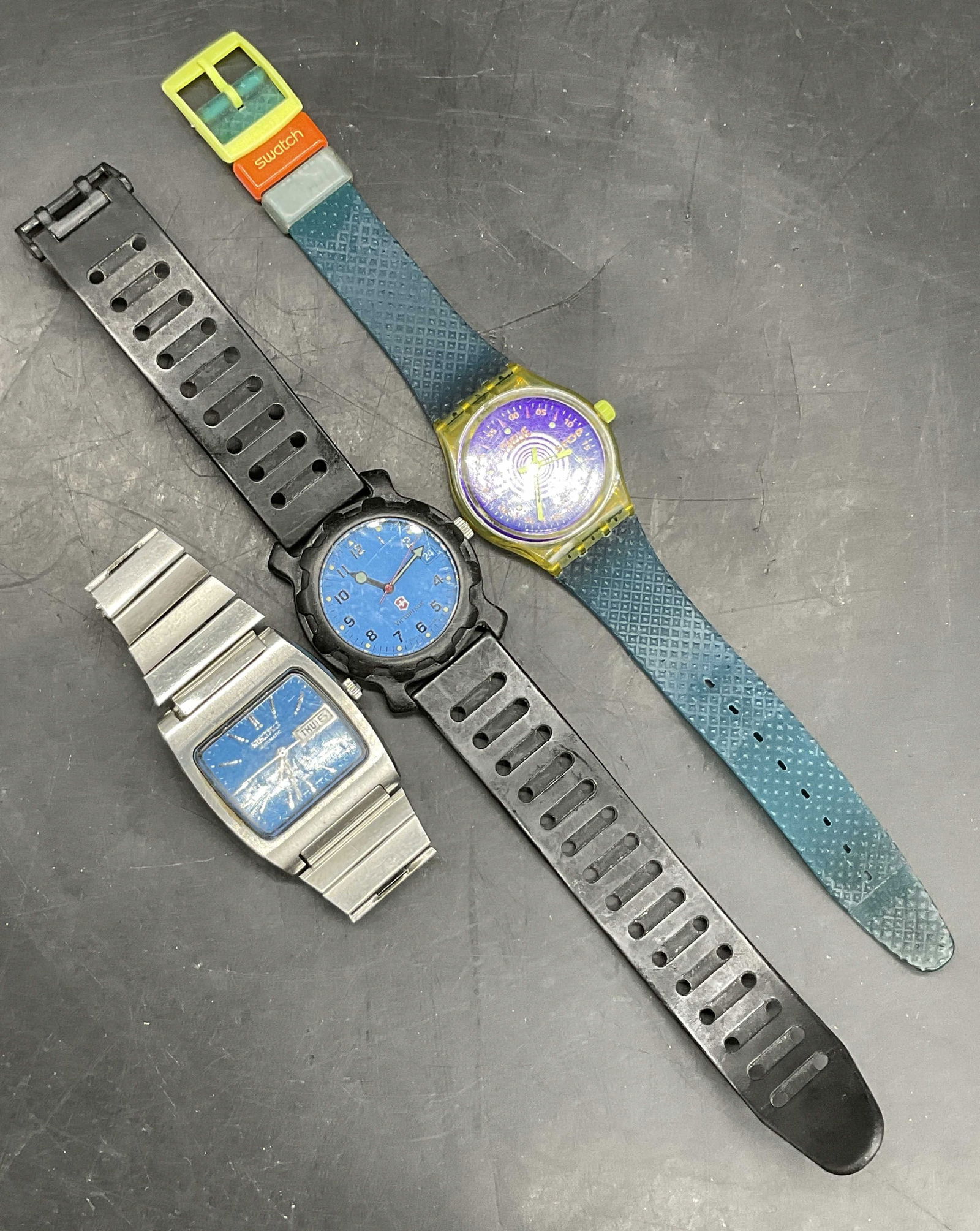 Lot 3 SEIKO, VICTORINOX, SWATCH Wristwatches: Three SEIKO, VICTORINOX, and SWATCH Wristwatches. The Swatch watch measures approx. 9 inches end to end. Pieces are crafted from metal or plastic components. Not tested for function. Surface wear cons