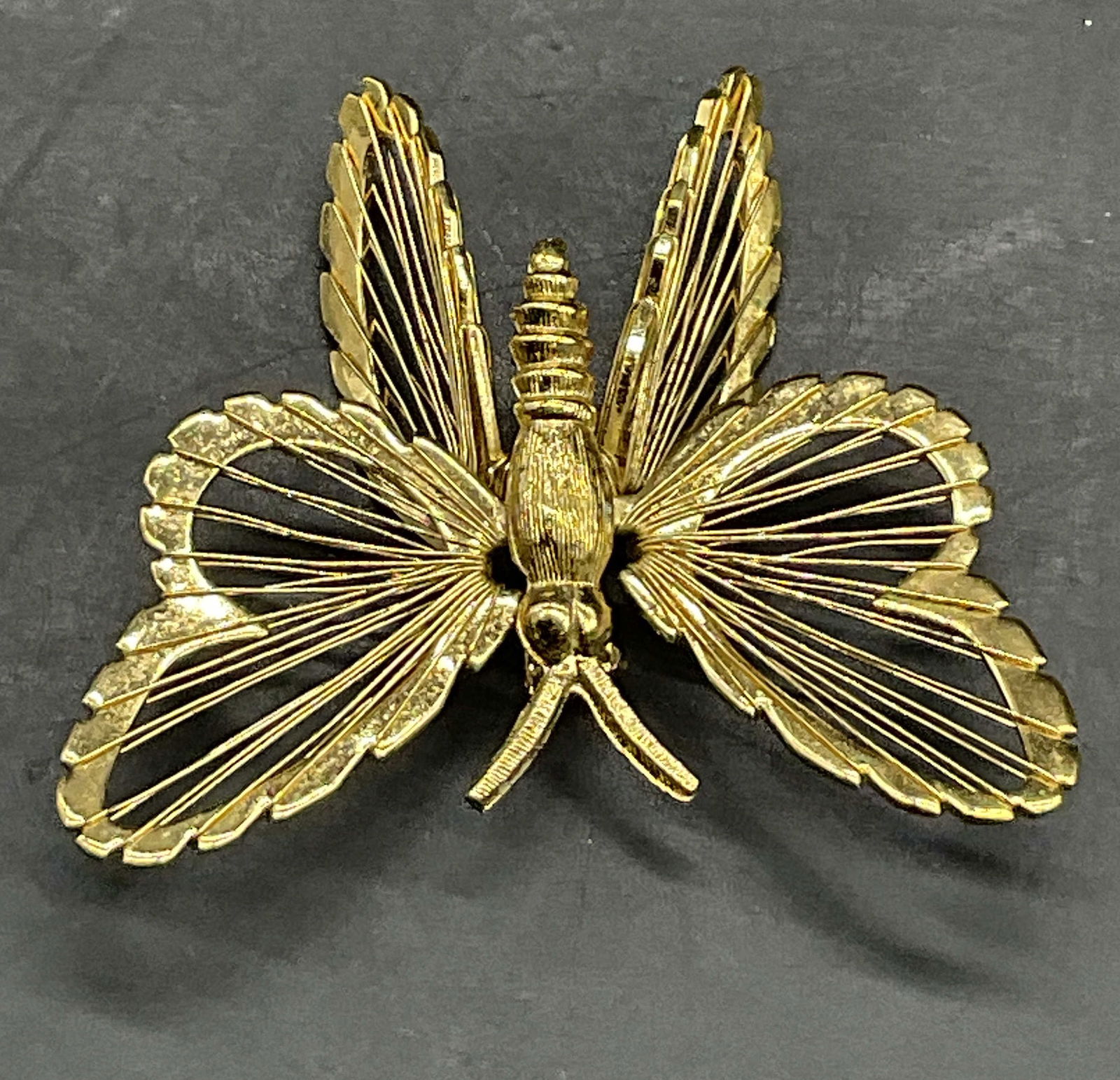 MONET Vintage Gold Tone Metal Butterfly Brooch: MONET Vintage Gold Tone Metal Butterfly Brooch. Reverse signed MONET. Metal pin closure to underside. Measures approx. 1.75L x 1.75W in. Wear consistent with age, use, and exposure. Vintage jewelry, V