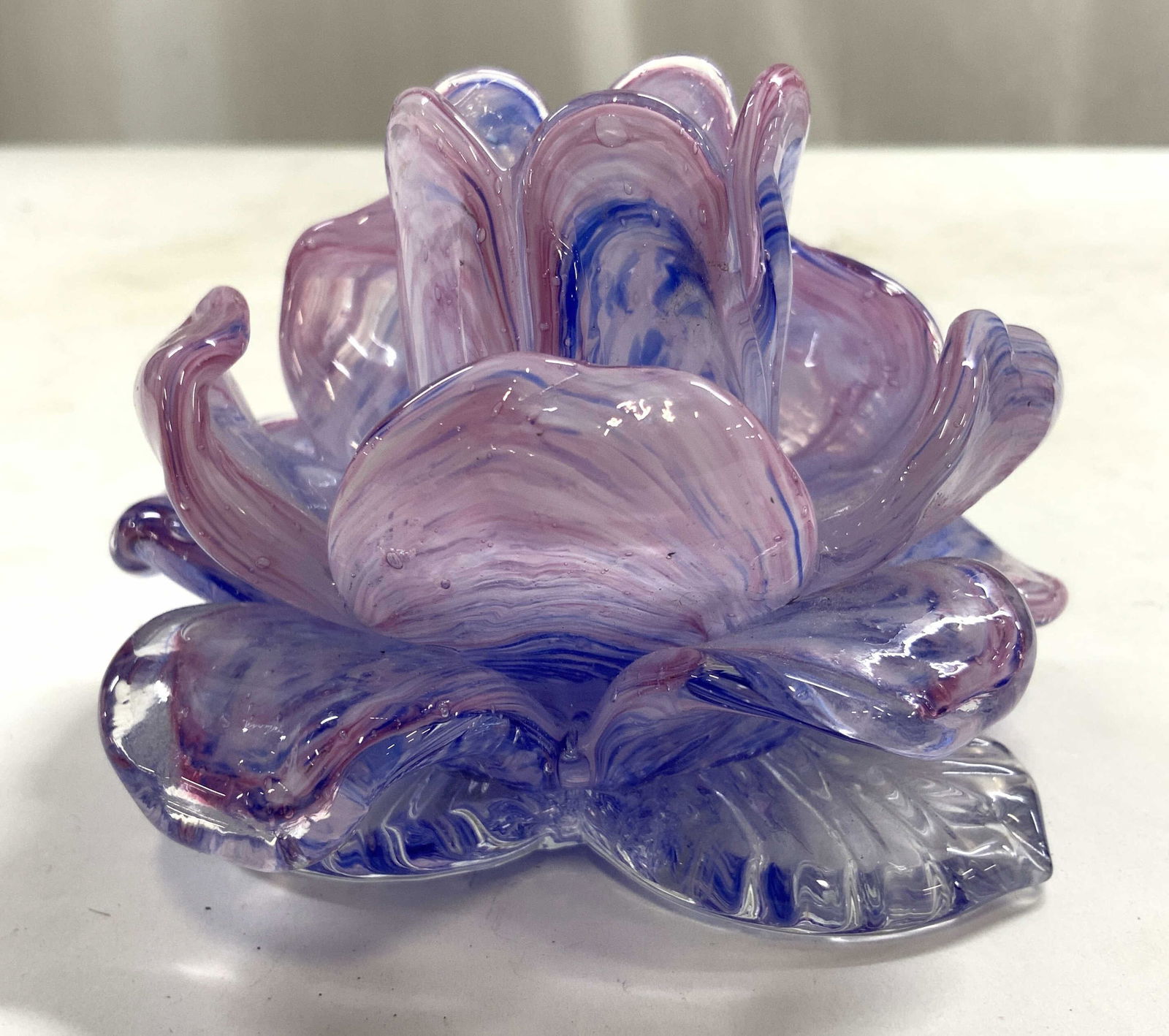 MURANO Art Glass Floral Candlestick: Candlestick appears to be MURANO glass (no apparent markings). Candlestick has blue, purple and lavender tones. Appears to possibly be hand molded. Candlestick has floral form. Piece measures approxim