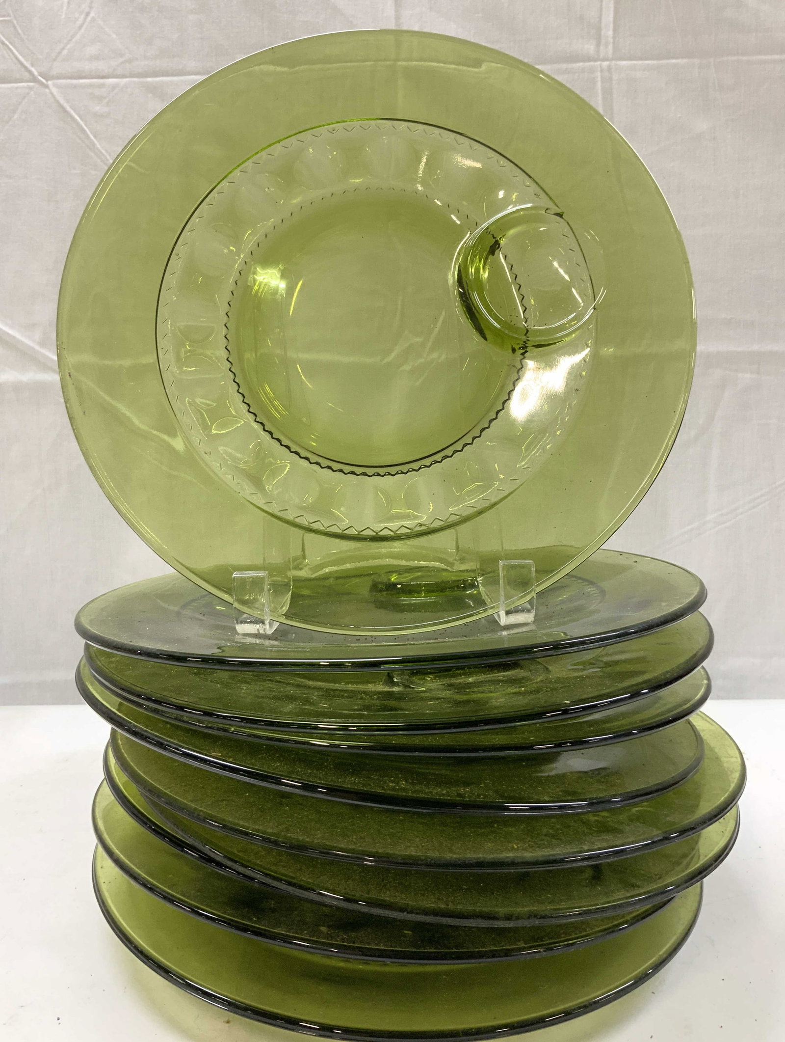 10 Kings Crown Pattern Olive Glass Snack Plate: 10 Kings Crown Pattern Olive Glass Snack Plate 10 snack plates that have an olive green color. Plate has a raised pattern & have a circular depression to hold snacks or a small container. Surface wear
