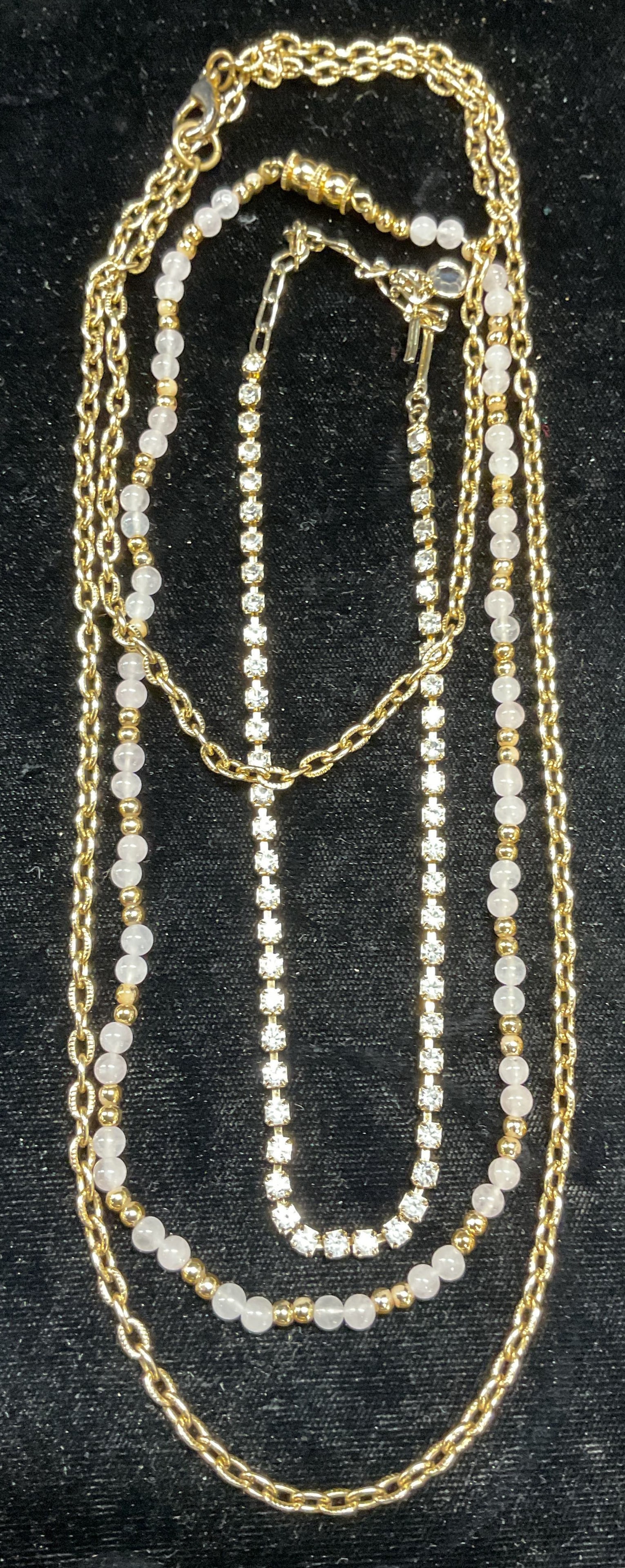 Lot 3 Gold Tone Rose Quartz Necklace +: Lot of 3 gold tone necklaces. Gold tone and rose quartz beaded necklace, gold tone and crystal necklace, and gold tone chain necklace. Longest drop length approx 16.5 inches. Crystal necklace needs un