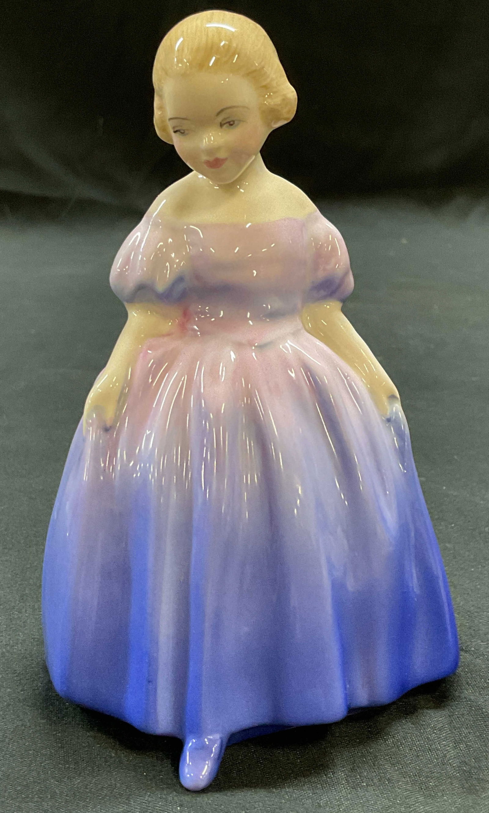 Royal Worcester Marie Bone China Figurine England: Royal Worcester fine bone china figurine. Girl in pink and blue dress. Signed. Hand painted. Made in England. Measures approx 3 x 2.75 x 4.75 inches. Some wear consistent with exposure. Royal Worceste