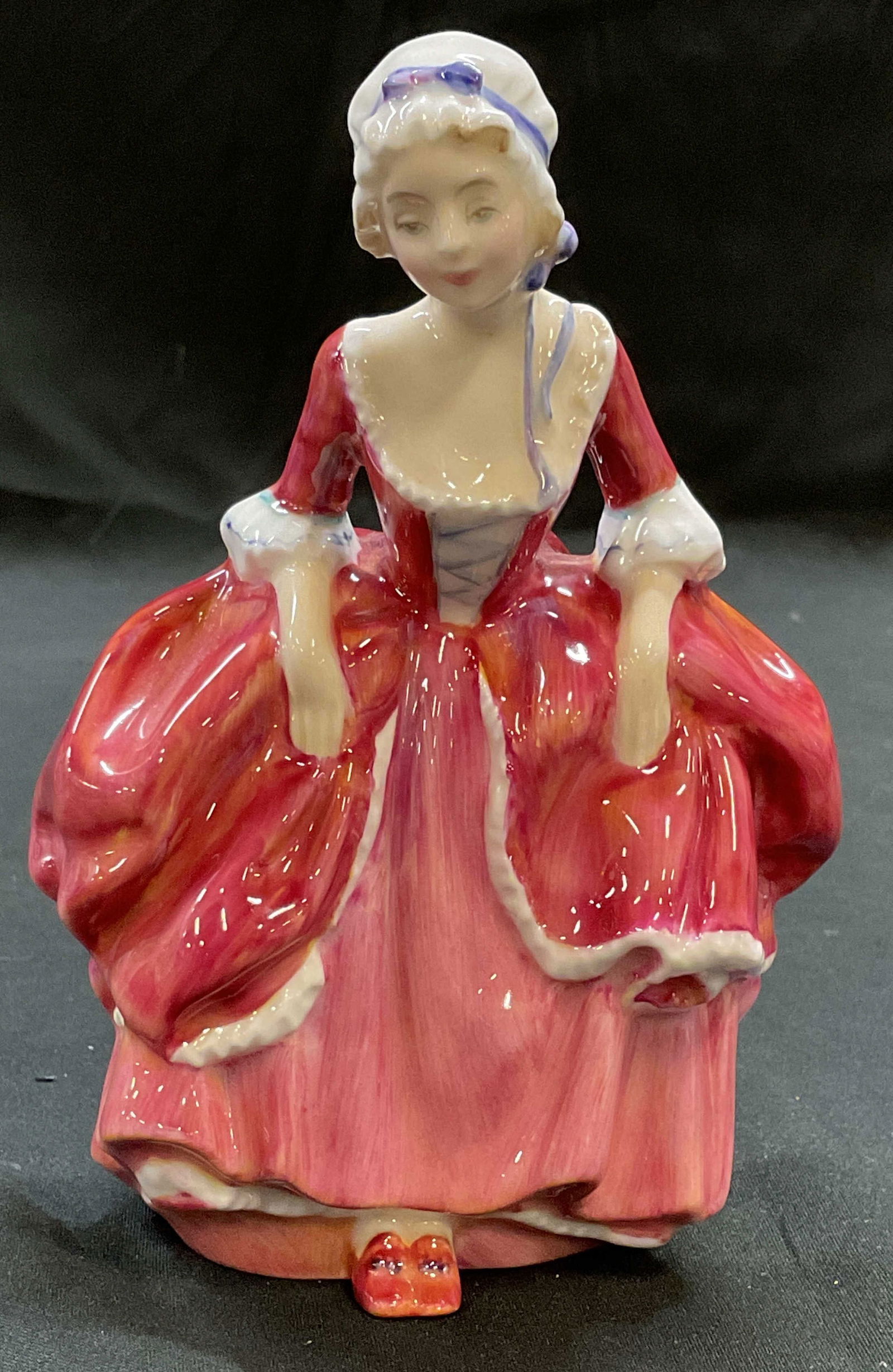 Royal Worcester Goody Two Shoes China Figurine Eng: Royal Worcester fine bone china figurine. Goody Two Shoes. Girl in red dress. Signed. Hand painted. Made in England. Measures approx 3.5 x 2.5 x 5.25 inches. Some wear consistent with exposure. Royal