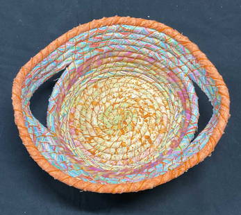 Signed Kohn Multicolor Cotton Textile Basket: Signed Beverly Kohn cotton textile wrapped basket with handles. Orange, yellow, and blue. Measures approx 10.5 x 9.5 x 3 inches. Some wear including loss to shape. Basket, textile basket, cotton baske