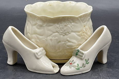 3 BELLEEK IRELAND Porcelain Bowl + Ceramic Shoes: One Vintage BELLEEK IRELAND Porcelain Bowl and Two Vintage Ceramic Shoe Figurals. Embossed floral motif to the bowl, underside signed BELLEEK IRELAND. The bowl measures approx. 2.5H x 3.25W in. Discol