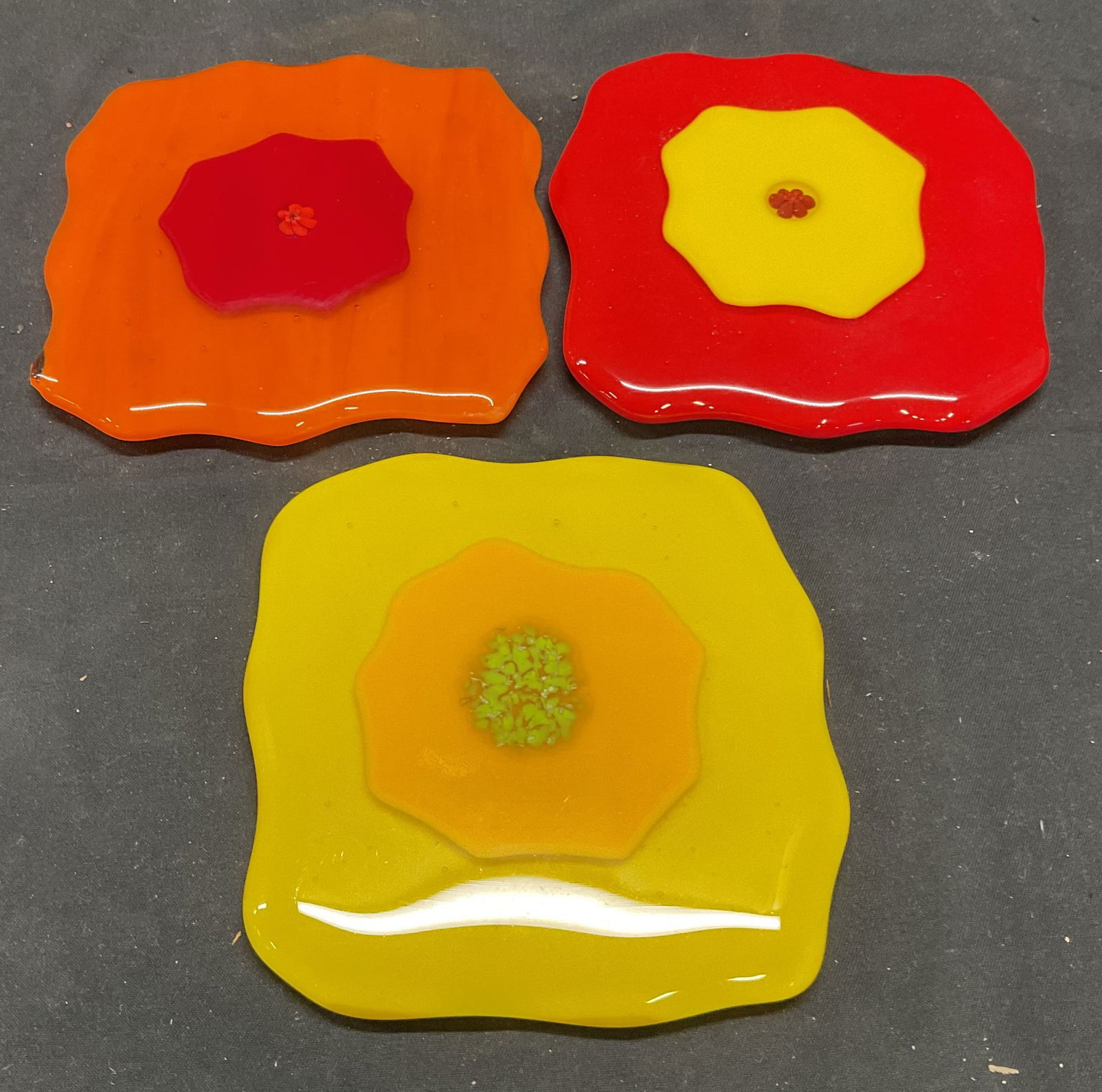 Lot 3 Art Glass Coasters: Lot of 3 yellow, orange, and red art glass coasters. Sizes vary slightly. Approx. 3.75 x 3.75 inches. All pieces have some wear consistent with exposure. Art glass, art glass coasters, yellow coaster,
