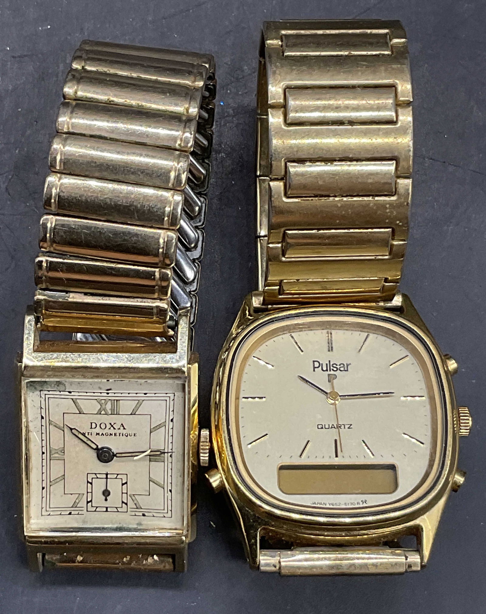 Lot 2 PULSAR & DOXAR Vintage Gold Tone Watches: Vintage PULSAR and DOXAR Gold Tone Metal Stretch Wristwatches. Not tested for function. Diameter of the Pulsar watch is 2.25 inches. One reverse reads Stainless Steel and the other reads From Mother T