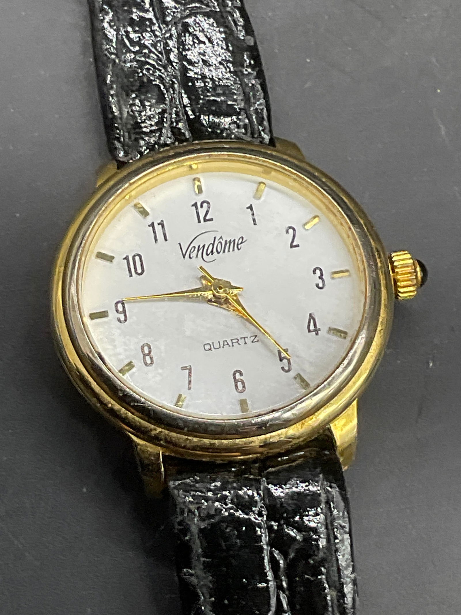 VENDOME QUARTZ Vintage Black Leather Watch: VENDOME QUARTZ Vintage Black Leather Watch. Gold tone metal hardware to the piece. Watch length measures approx. 7.5 inches. Watch face reads VENDOME QUARTZ. Band reads GENUINE LEATHER. Loose thread,