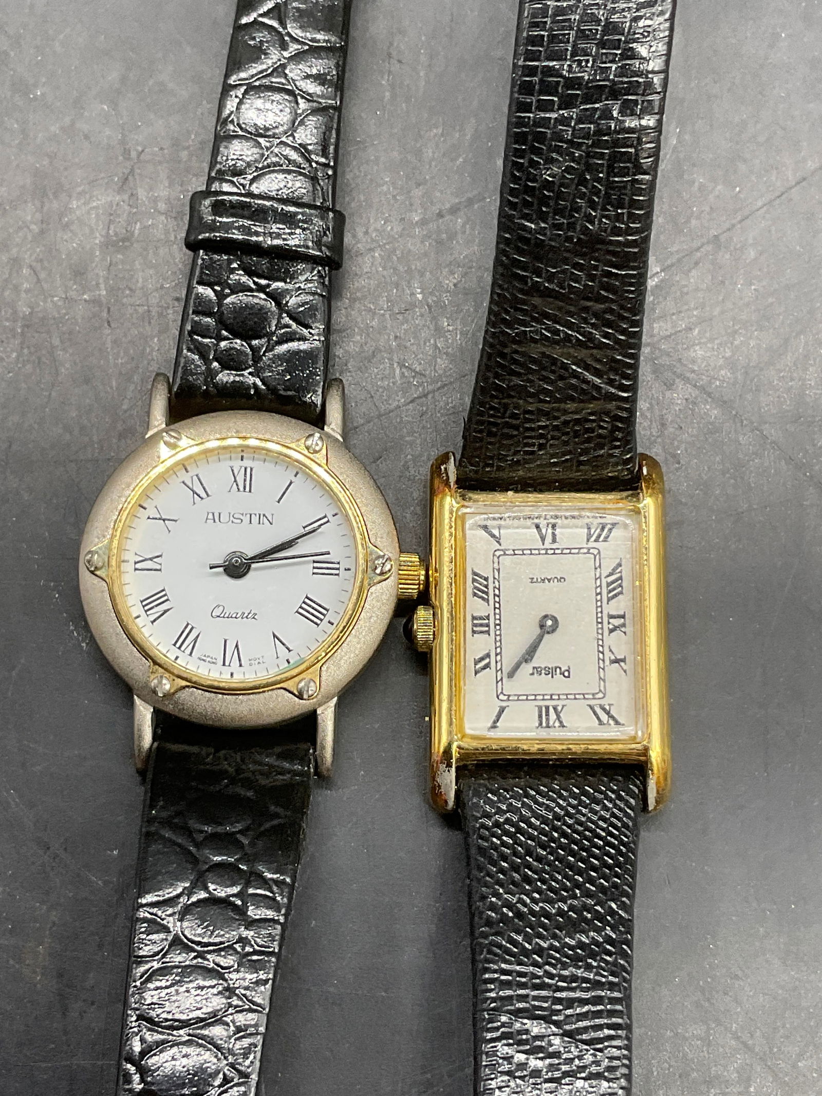 2 PULSAR & NWT AUSTIN Quartz Black Leather Watches: Lot of Two PULSAR & NWT AUSTIN Quartz Black Leather Watches. The Austin watch has the original tag attached. Both pieces feature leather bands, white watch faces, and gold tone metal hardware. One rec