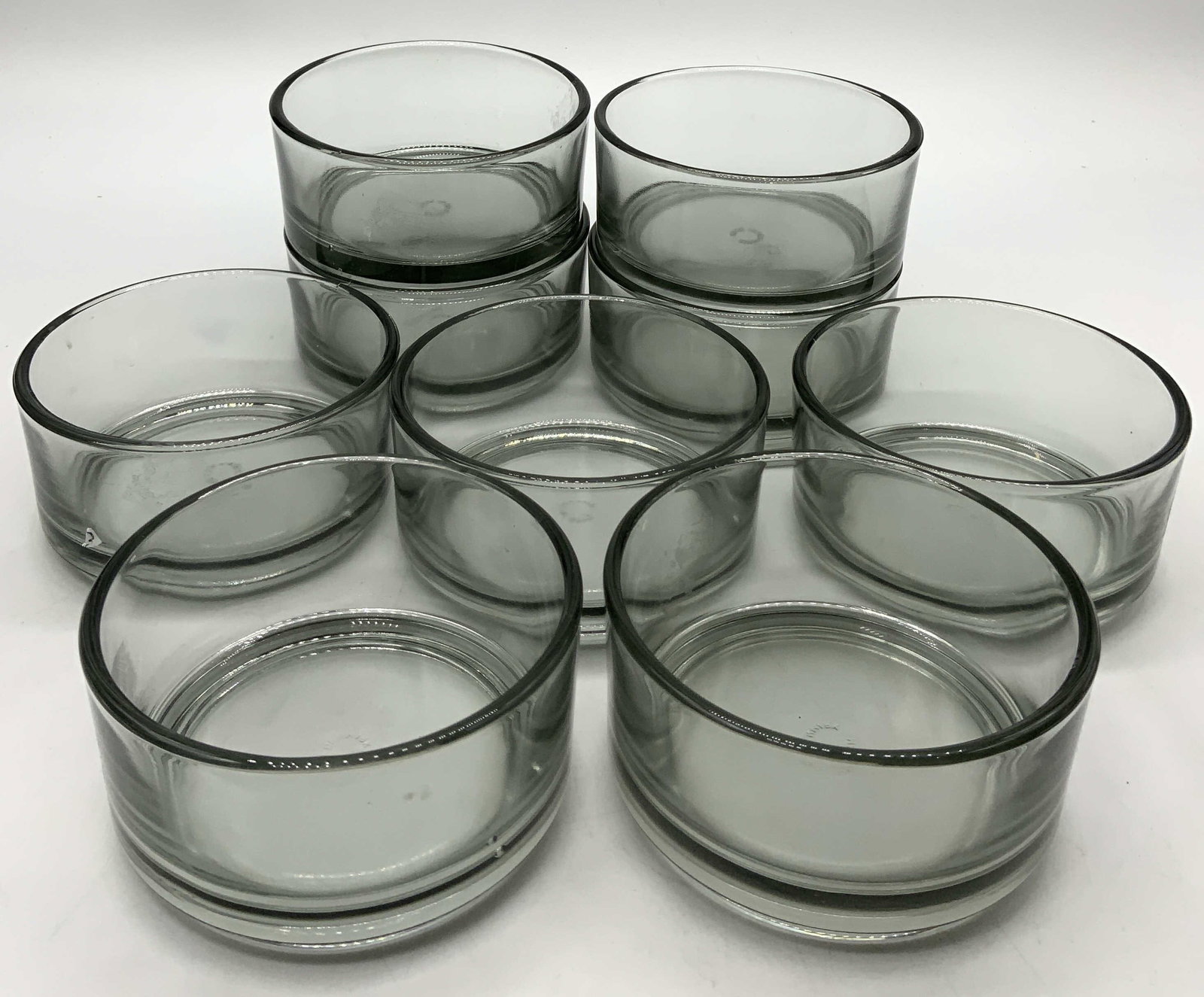 9 HOLMEGARRD Smoked Gray Glass Stacking Bowls Denmark: 9 HOLMEGARRD Smoked Gray Glass Stacking Bowls 9 glass stacking bowls, they have a smokey gray color. Underside reads MADE IN DENMARK. Surface wear consistent to age, use & exposure. Measurements: leng