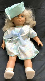 FAMOSA Girl Doll Wearing Dress & Hat: Doll appears to be FAMOSA (No apparent tags or markings). Doll has blue eyes, blonde hair. Figure is wearing a light multi toned dress and light blue hat with white shoes. Doll measures approximately