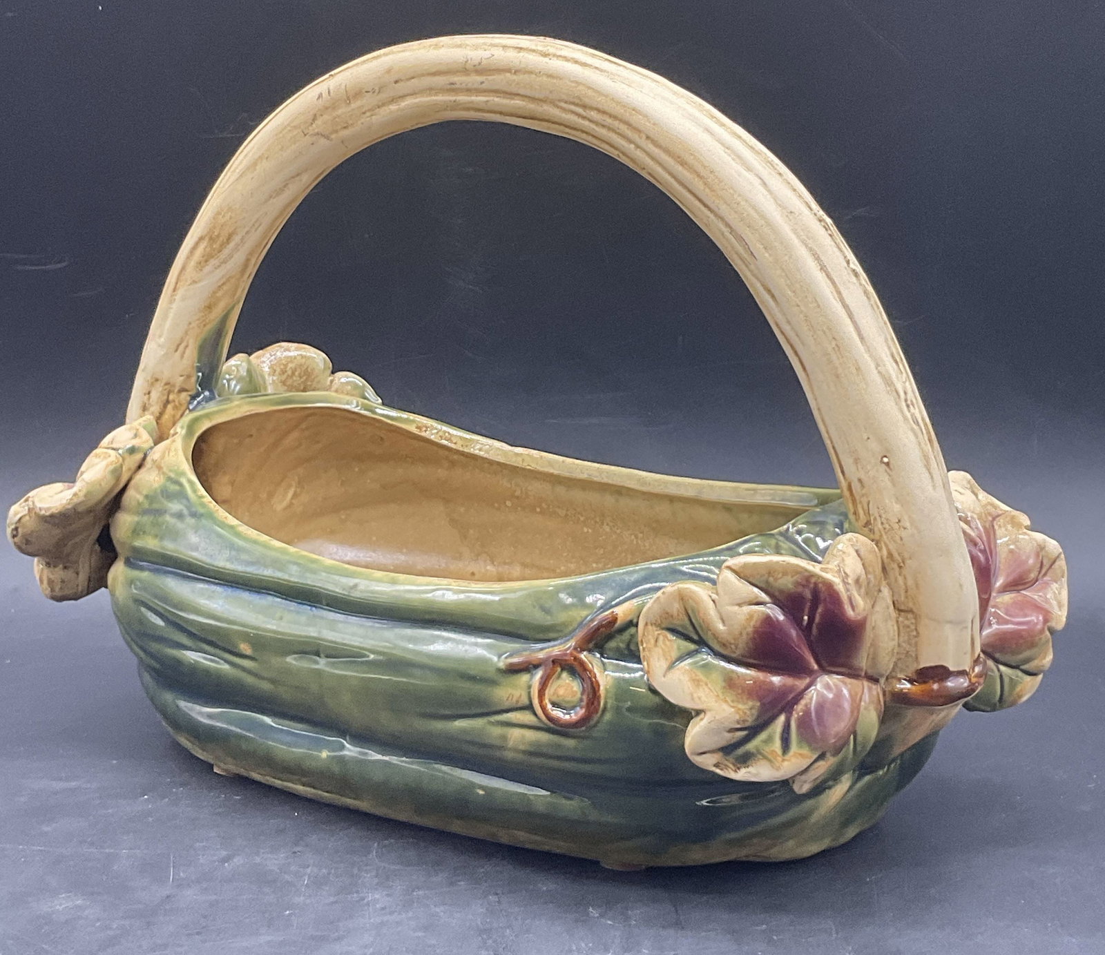 Vintage Hand Painted Vegetal Motif Majolica Basket: Vintage Hand Painted Vegetal Motif Majolica Pottery Basket. Handcrafted and glazed. Vegetal base featuring raised leaf motifs. Measures approx. 7.75H x 10.5W in. Crazing, chipping, discoloration, resi