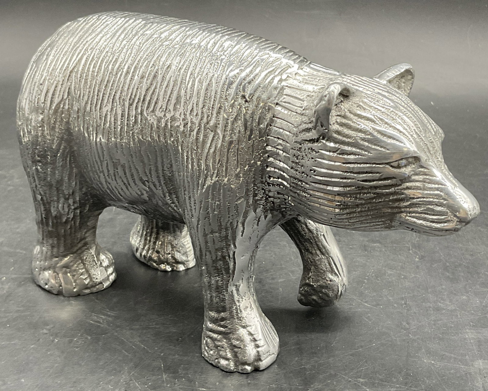 Silver Tone Metal Standing Bear Figural: Silver Tone Metal Standing Bear Figural. Etched details throughout. Measures approx. 4.5H x 8W in. Measured at widest point. Surface wear consistent with age, use, and exposure. home decor, home accen