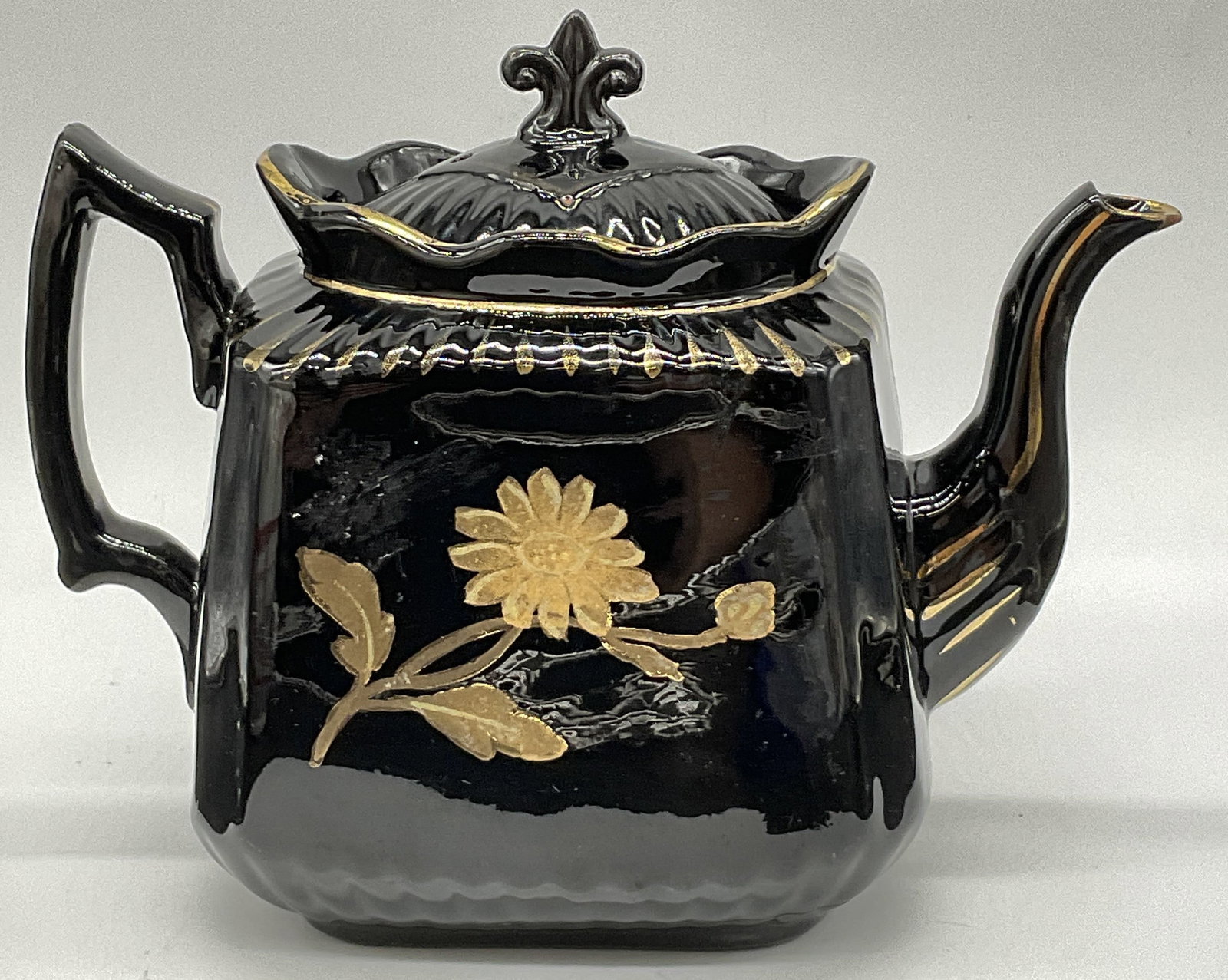 Vintage Hand Painted Black Pottery Teapot, Lid: Vintage Hand Painted Black & Gold Toned Floral Pottery Teapot. Lidded. Writing to the underside, illegible. Measures approx. 8W x 6H in. Width measured at widest point. Chipping, wear to paint, and su
