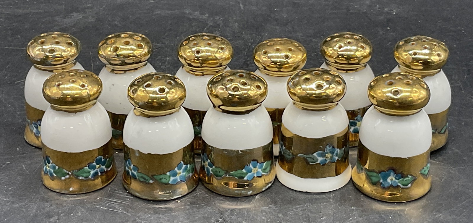 11 Vintage Hand Paint Porcelain Seasoning Shakers: Set of 11 Vintage Hand Painted Porcelain Seasoning Shakers. Pierced tops and drilled holes to the undersides. Decorated with blue florals and gold tone paint. Measures approx. 1.5H x 1W in. Chipping, 