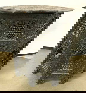 Vntg Moorish Carved Wooden Side Table: Side table is vintage and wooden. Piece has Intricately carved floral motif detail. Tabletop has octagonal form. Table top fits into folding base. Table measure approx 22 inches tall 21 inches wide. E