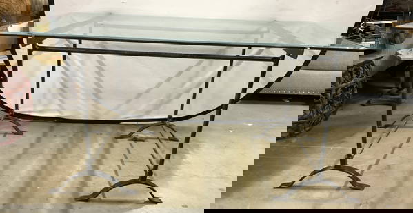 Iron Base Glass Top Dining Table: Dining table has a black toned iron base. Piece has a beveled rectangular glass top with rounded edges. Table has 4 feet with stretchers in between supports. Table measures approximately 60 inches lon