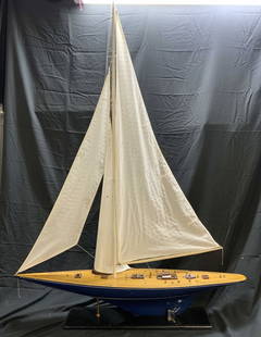 Americas Cup yacht Endeavour II Scale Model 62in H: Scale model depicts Americas Cup yacht Endeavour II. Model boat is wooden. Piece has tan & blue tones. Boat has white toned sails. Lot includes black toned stand. Piece measures approximately 62 inche