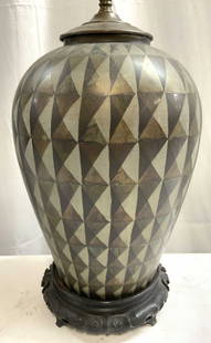 Vintage Metal Table Lamp W Geometric Pattern: Lamp is vintage. Piece has geometric pattern detail. Lamp has black toned carved base, appears to be wooden. Lamp is metal. Piece includes harp and finial. Lamp measures approximately 25 inches tall 7