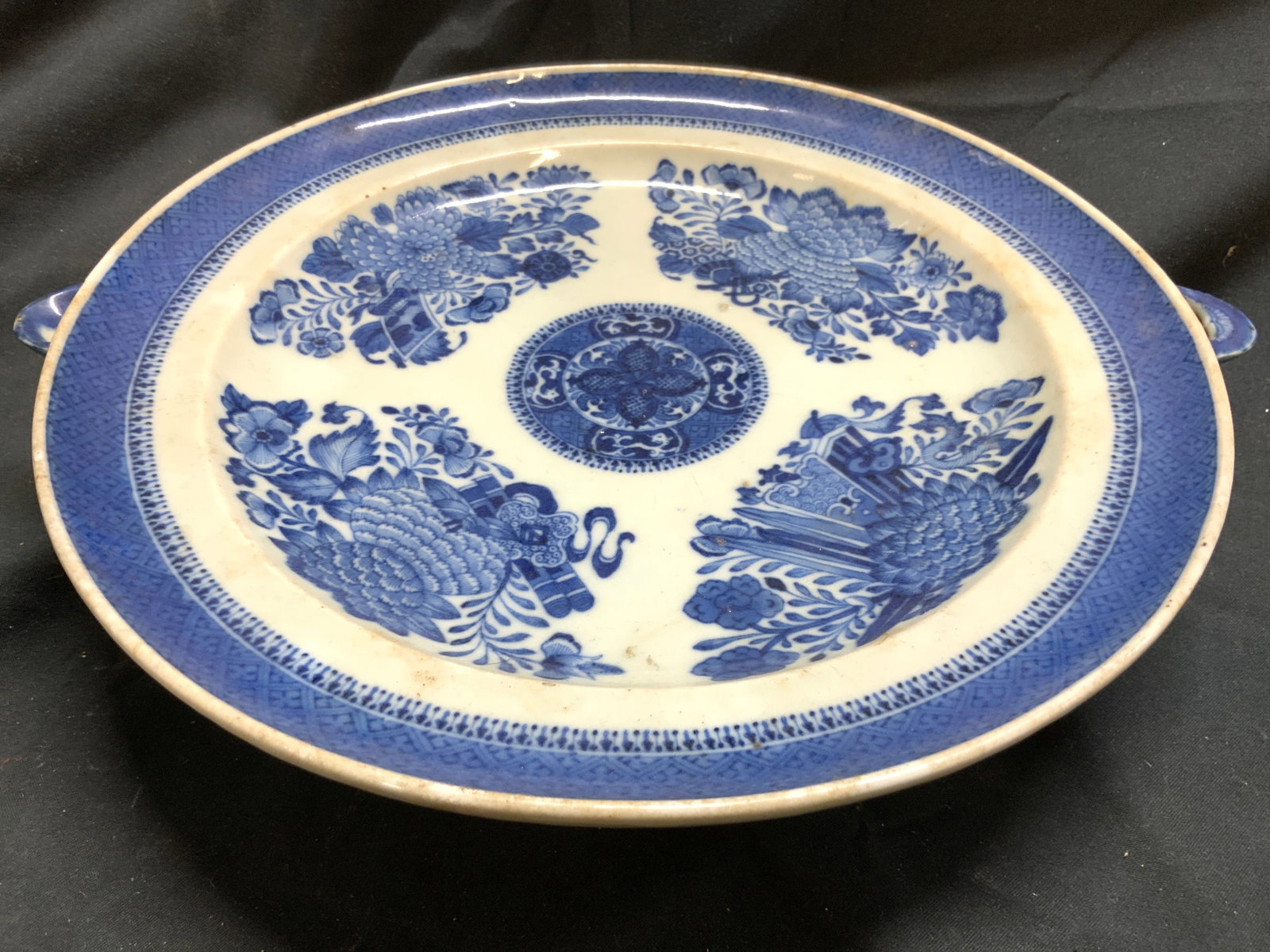 Antq Fitzhugh Pattern Porc Warming Bowl W Spouts: Warming bowl is antique. Piece is blue and white toned with floral and leaf Fitzhugh pattern. Sides of dish have spouts. Asian warming bowl. Piece measures approximately 11.75 inches wide 9.75 inches 