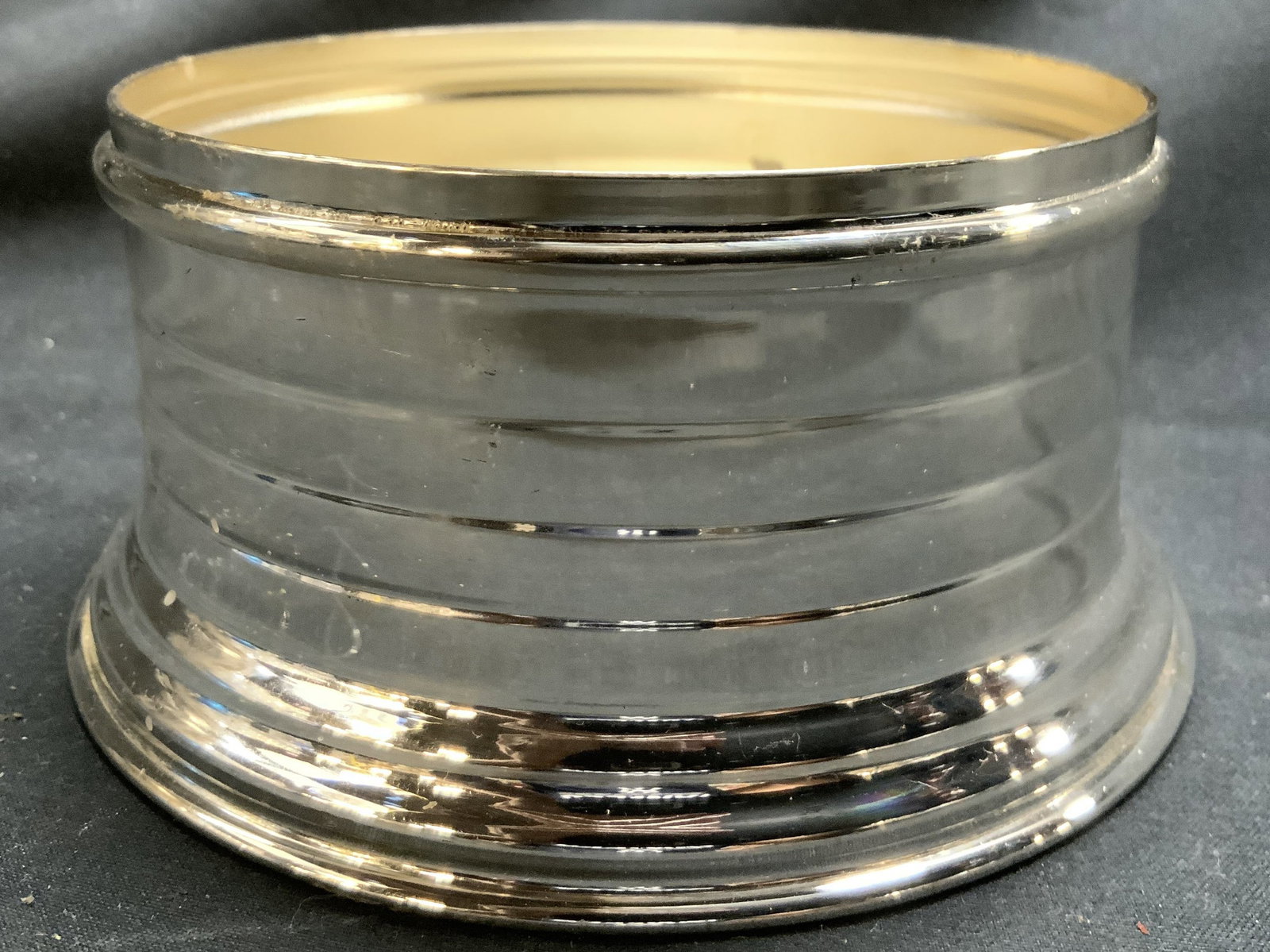 Silver Plate Vintage Ribbed Wine Coaster: Interior is inscribed SILVER PLATE. Coaster has ribbed exterior. Base area expands outward slightly. Wine coaster is silver plate. Piece measures approximately 4.5 inches wide 2.25 inches tall. Wine c