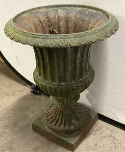 Vintage Iron Urn Planter, 22.5 Inch Height: Vintage Iron Urn Planter. A green hue to the piece. Embossed metalwork designs. Weighty piece. Measures approx. 17W x 22.5H in. Losses and chipping to finish and iron. Discoloration and surface wear p