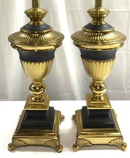 Pr Neoclassical Brass & Metal Urn Form Lamps: Lot includes 2 lamps. Each are black and gold toned. Lamp crafted from brass and black toned metal. Neoclassical style urn form lamps. Each have 4 scrolled feet. Lamps include gilt metal harps and fin