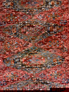 Vintage Handmade Fringed Persian Wool Area Rug: Rug is handmade. Piece is vintage, appears to be Persian. Rug is red with intricate multi toned floral & geometric detail. Rug has knotted cream toned fringes at edges. Piece measures approximately 97