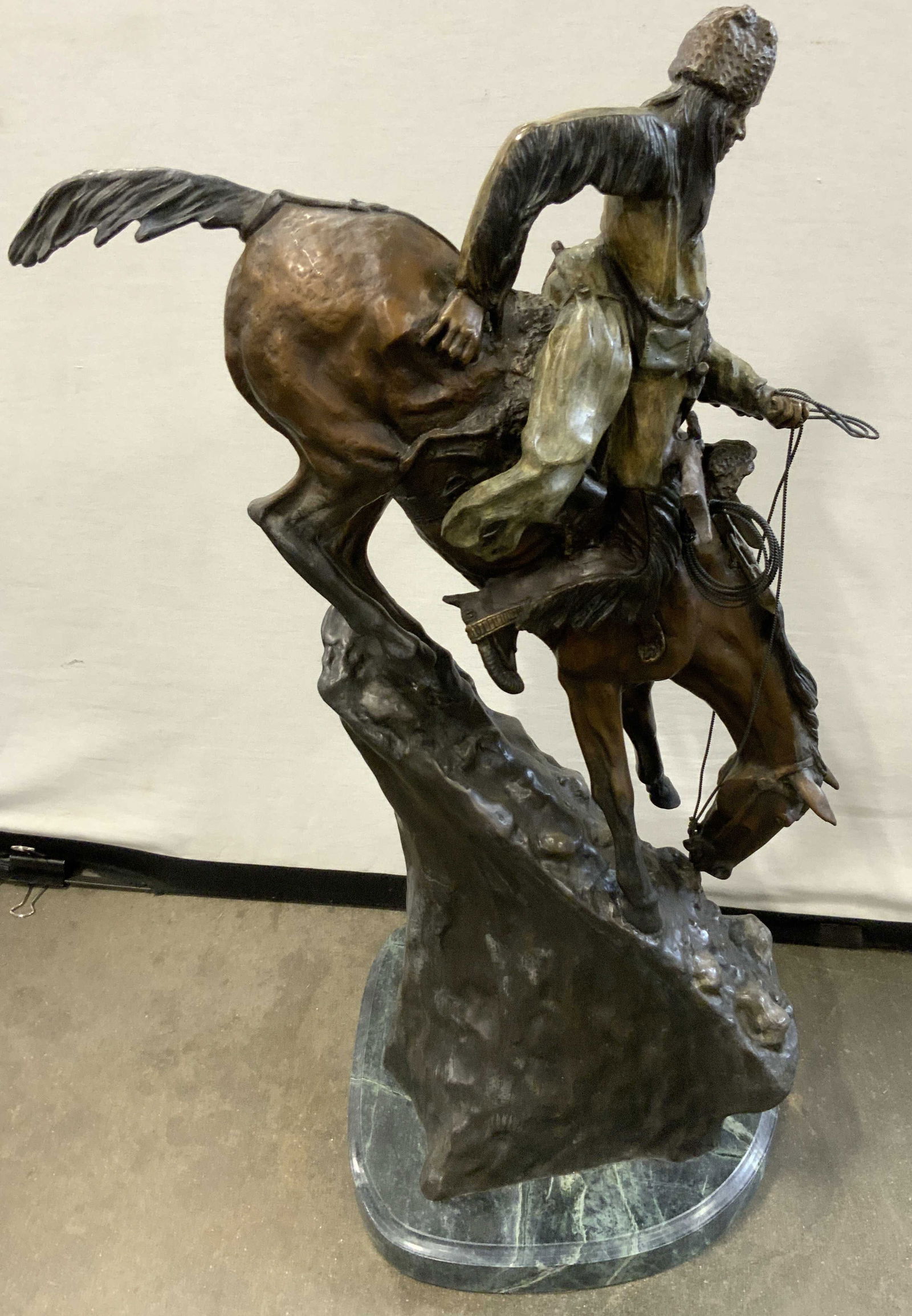 FREDERIC REMINGTON MOUNTAIN MAN Brnz Sclpt: Plaque on front side reads FREDERIC REMINGTON MOUNTAIN MAN. Sculpture is bronze with forest green toned marble base. Piece depicts a male figure riding horseback down a steep slope holding a rifle. Me
