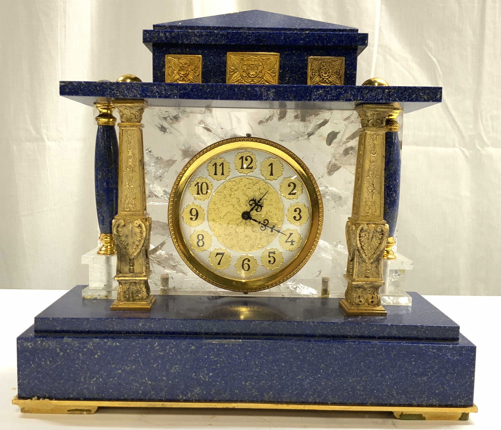 Louis XVI Gilt & Lapis Lazuli Mantel Clock: Mantel clock is Louis XVI style. Gilt metal and lapis Lazuli Mantel clock. Piece has silver and gold toned face with black number and hands. Sides have column supports & glass backside. Intricate scro