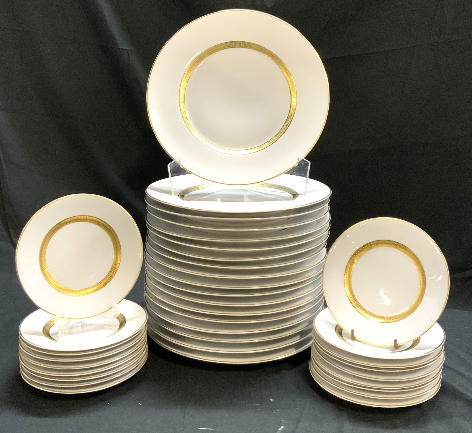 CM HUTSCHENREUTHER HOHENBERG Set 36 Porcelain: Undersides are marked CM HUTSCHENREUTHER HOHENBERG MASTERPIECE. Lot includes 18 dinner plates, & 18 bread plates. Each piece in set is white with gilt inner and outer rim areas. Dinner plate measures
