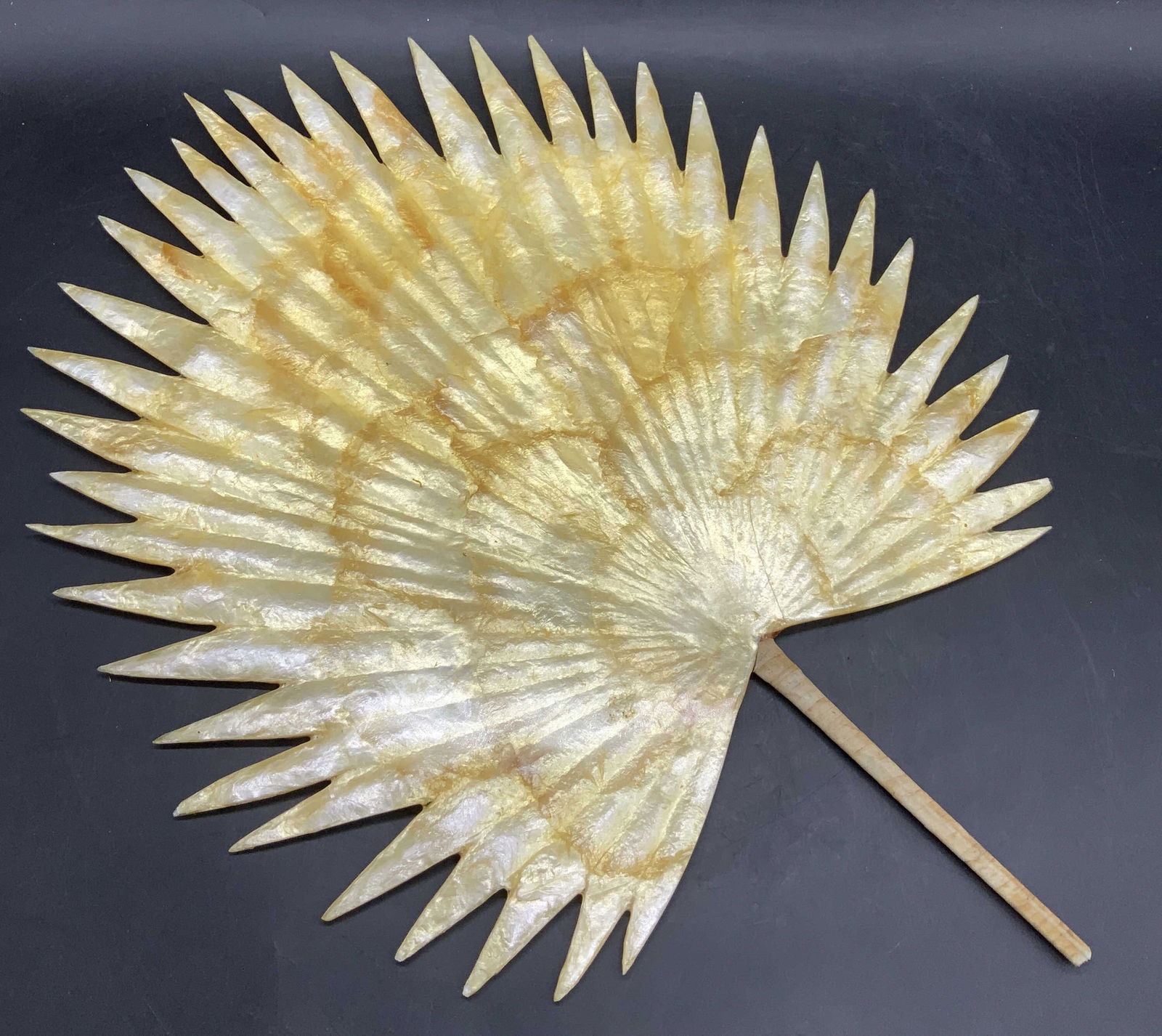 Vintage Handmade Lustrous Lacquered Leaf Fan: Vintage Handmade Lustrous Lacquered Leaf Handheld Fan. Primarily a golden yellow hue. Wrapped natural material handle. Measures approx. 18L x 13W in. Chipping, cracking, loose pieces, and surface wear